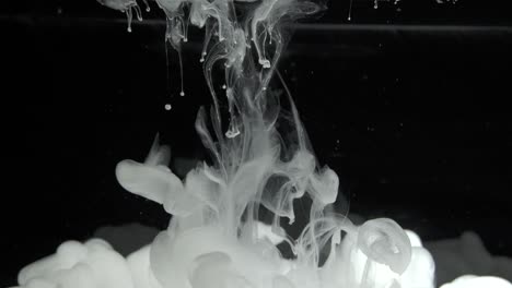 white ink effect in water filmed on black background