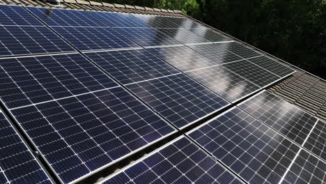 Vista-Aérea-De-Las-Nubes-Reflejadas-Desde-Paneles-Fotovoltaicos-En-El-Techo-De-Una-Casa.