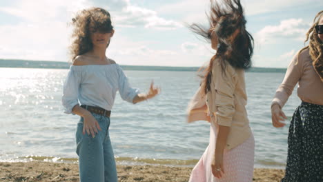 three women dancing on the beach