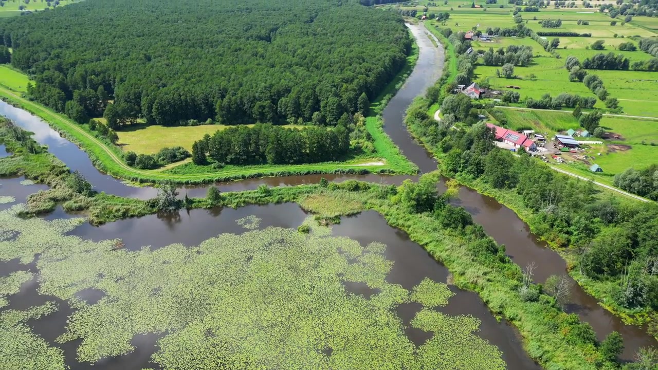 Letecký pohled na rozvodněnou řeku přetékající do přírodní krajiny