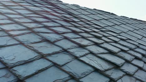 building with roof made of cut stones, shaped and positioned in a geometric way for covering roofs in rural areas - aerial, close up