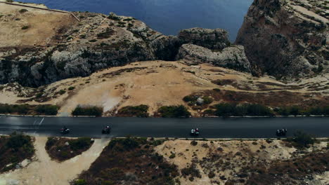 tourists riding atvs enjoying drive along dramatic coastal road gozo, malta