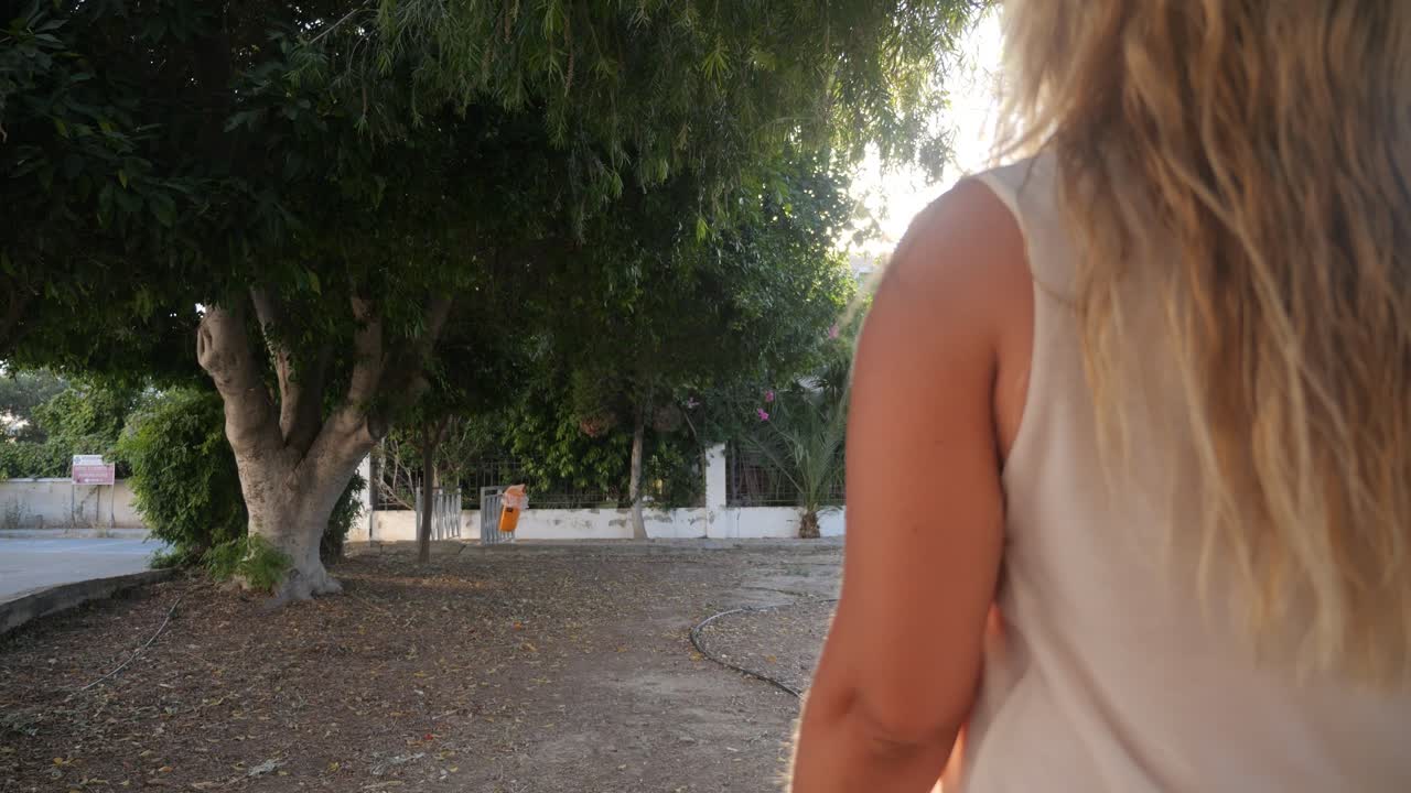 한 여자 가 공원 에서 편안 한 산책 을 한다