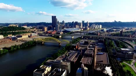 drone fly over aerial, birds eye shot flying towards david mccullough, 16th street bridge and industrial factories along the allegheny river on a partly cloudy day in pittsburgh, pennsylvania