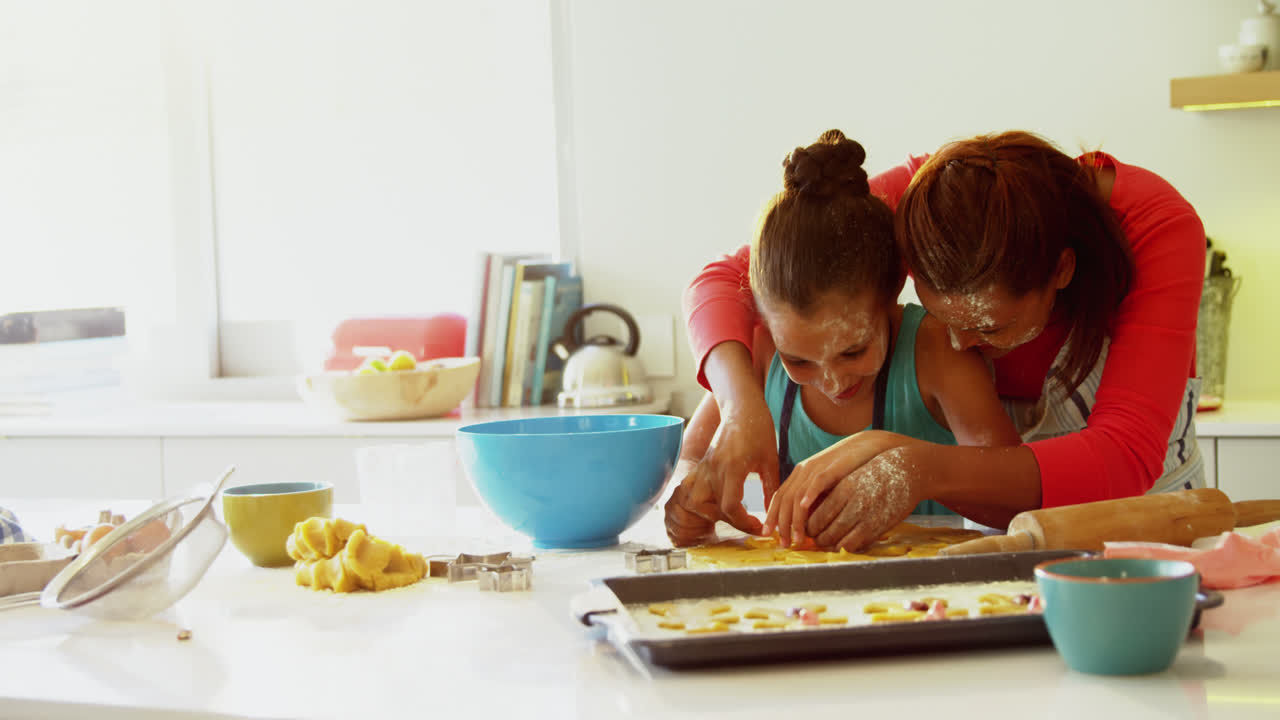 madre e hija preparando galletas en la encimera de la cocina 4k