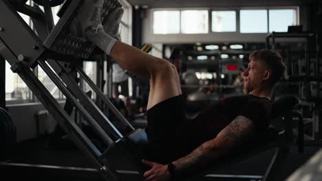 man working out on leg press machine at the gym