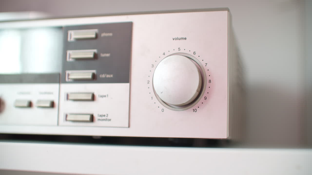 실버 사운드 장치에서 볼륨을 조정하는 낮은 각도 클로즈업 샷