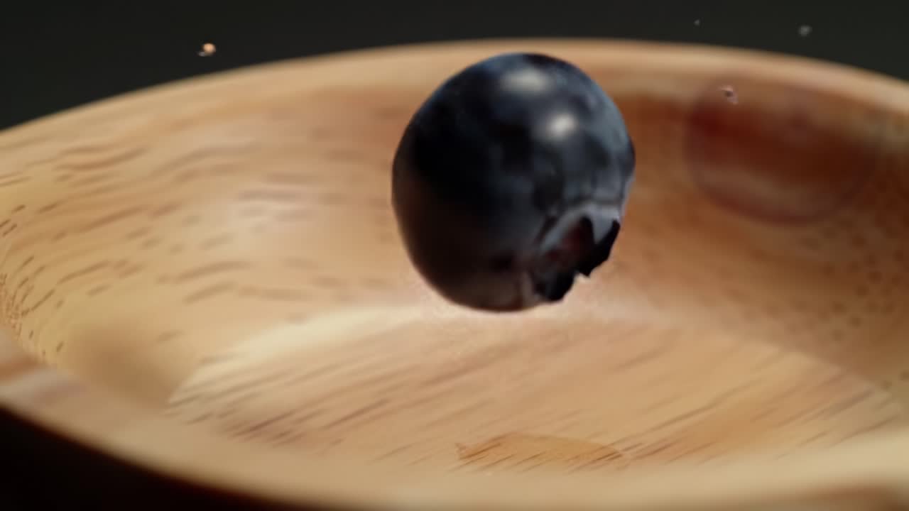 Floating Blueberry Captured Above a Wooden Bowl During Vibrant Kitchen Setup