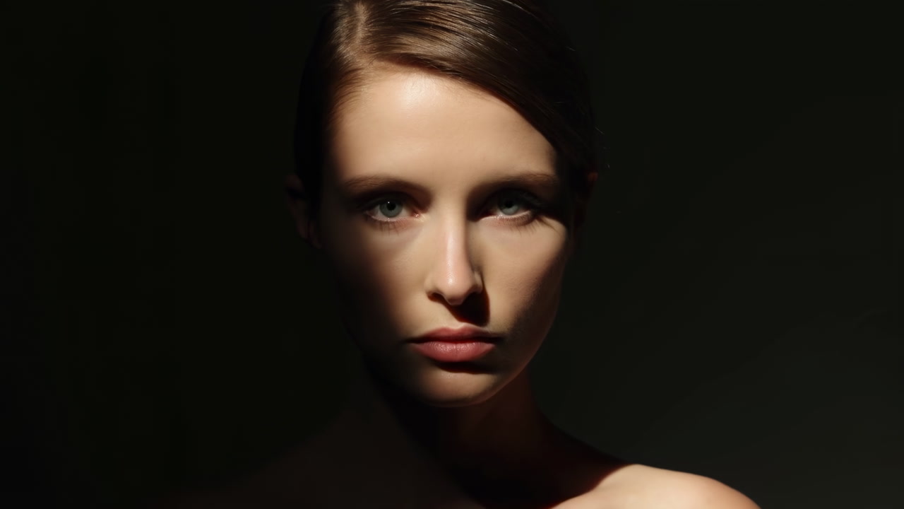Dramatic Portrait Caucasian Female Model Under Spotlight With Lowkey Studio Lighting, Deep Shadows Sculpting