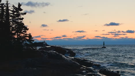 Waves-crashing-on-rocks-at-sunrise-on-Lake-Superior,-Grand-Marais,-Minnesota