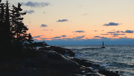 waves crashing on rocks at sunrise on lake superior, grand marais, minnesota