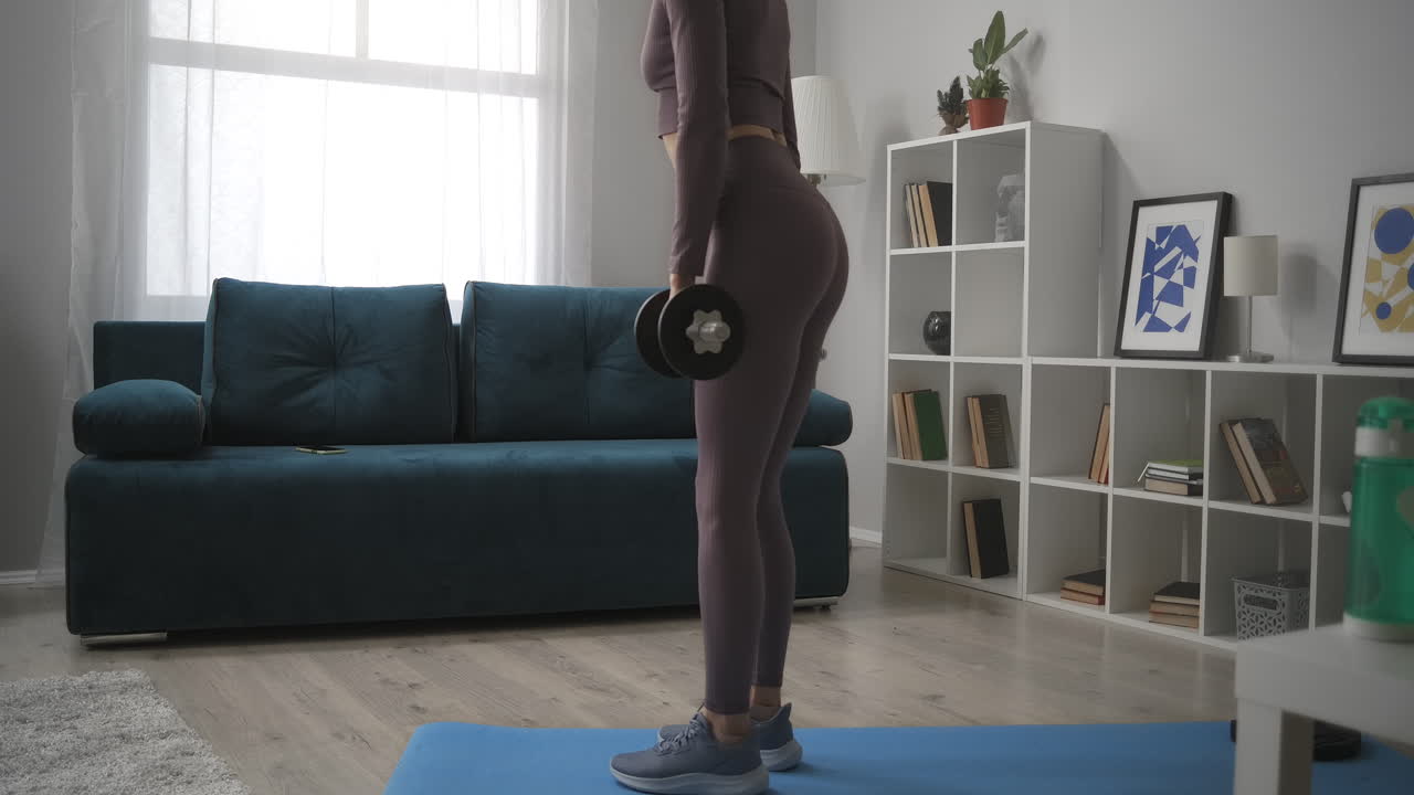 mulher está inclinada para a frente com grandes halteres treino em casa traseira e frontal vista de figura feminina esbelta desportiva que se preocupa com a saúde do corpo e beleza