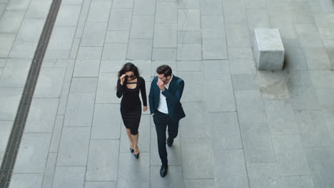 Top-view-of-cheerful-couple-in-stylish-suits-walking-outside