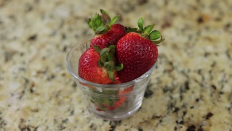 Fresas-Guardadas-En-Un-Pequeño-Recipiente-De-Vidrio-Sobre-Una-Superficie-De-Mármol