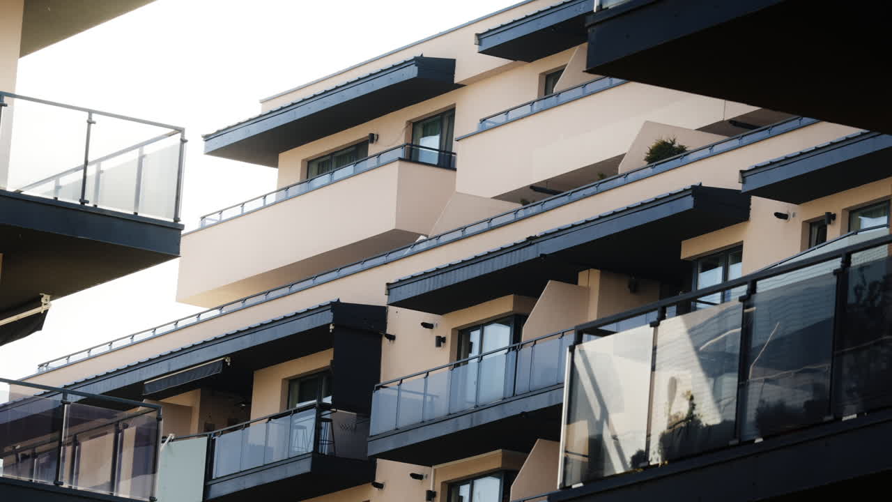 Udsigt fra en altan i et luksuslejlighedskompleks, udvendigt af boligbygninger, en solrig aften