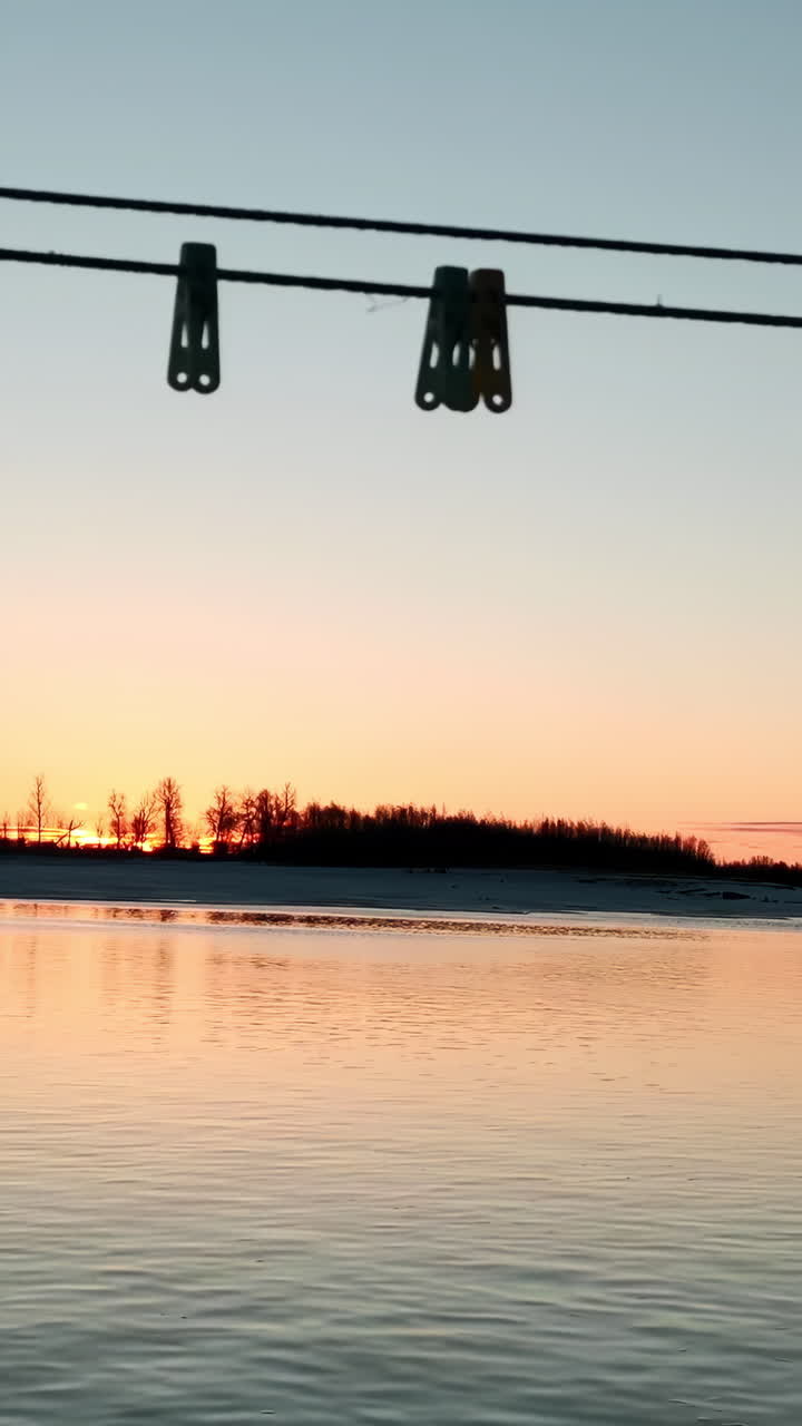 옷줄로 얼어붙은 강을 가로질러 해가 뜨는 것