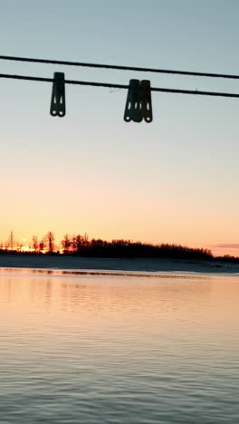 sunrise over a frozen river with clothesline