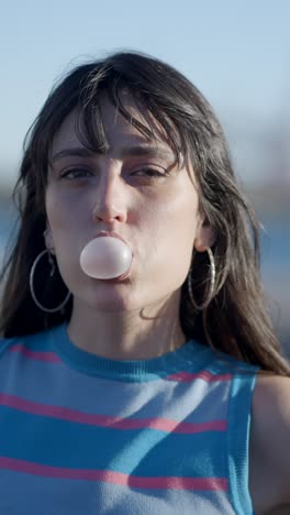 young woman blowing and chewing bubble gum
