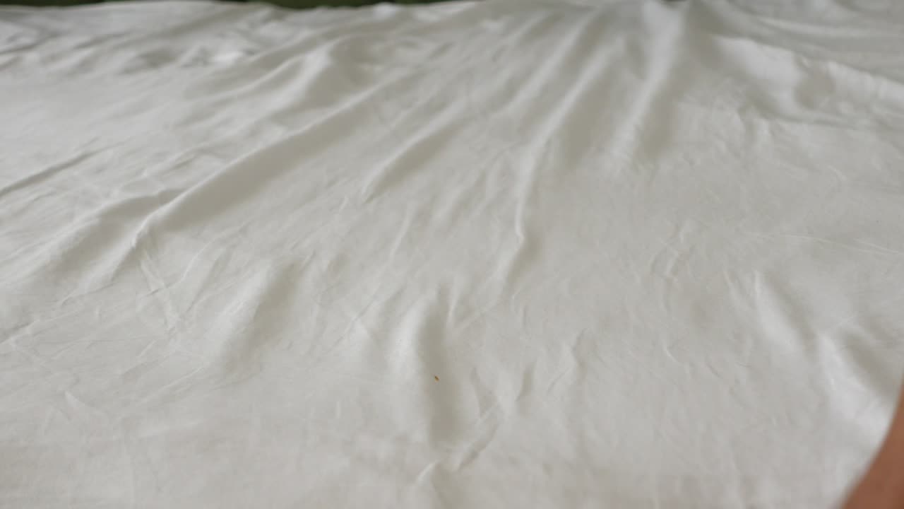 침대 시트를 만지는 사람