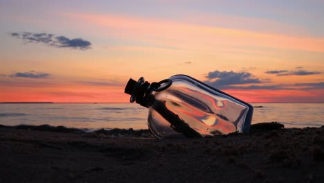 Message-in-the-bottle-against-the-Sun-setting-down