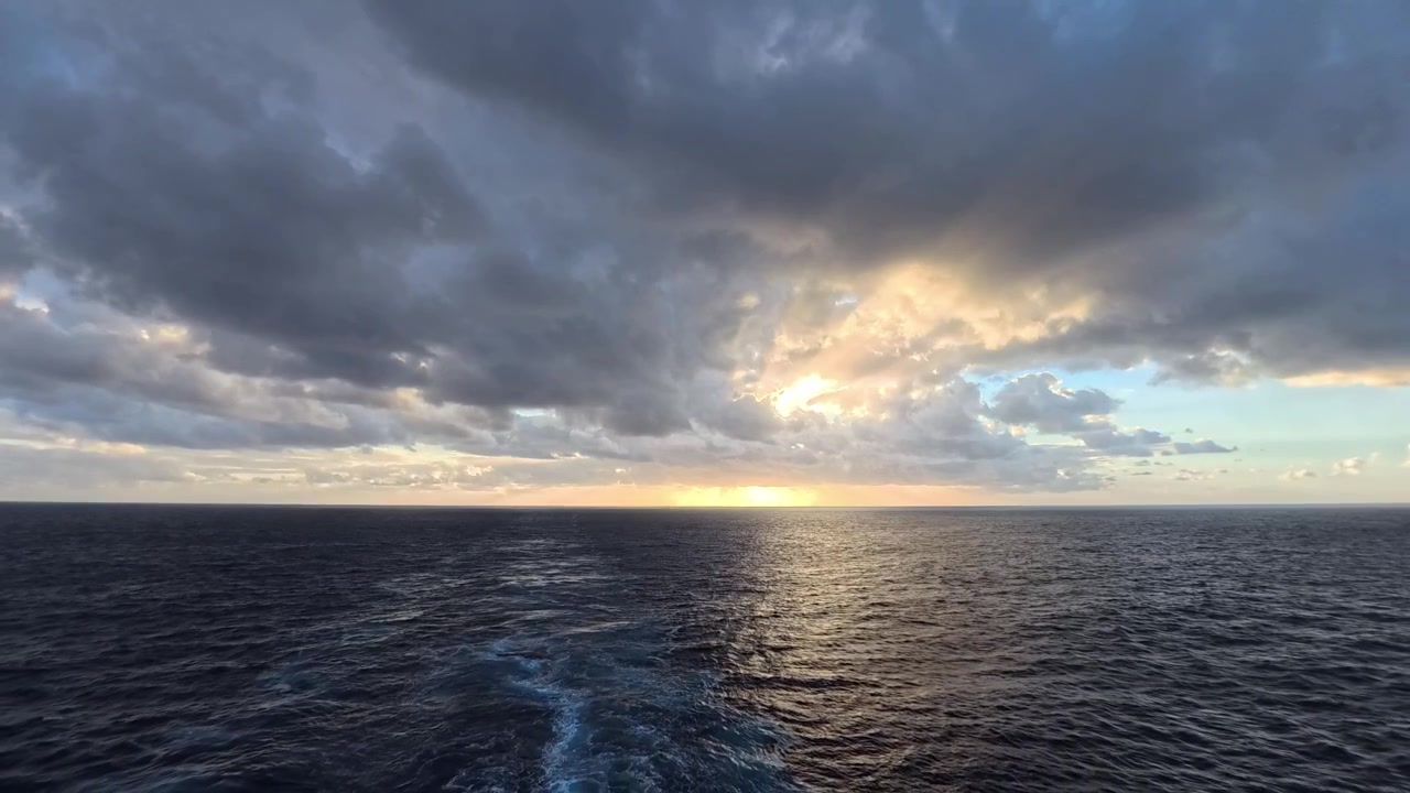 Serene Ocean Sunset with Sun Rays Breaking Through Dramatic Clouds