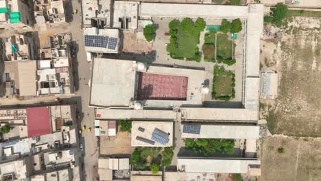 Aerial-zoom-out-shot-of-Darul-Uloom-Hussainia-University-at-Shahdadpur,-Sindh-in-Pakistan-at-a-sunny-afternoon