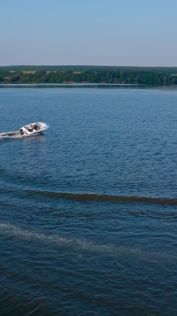 Kyiv, Ukraine, 2 May 2025: Motor boat travels along river. Aerial view of high speed motor boat floating on river. Vertical video