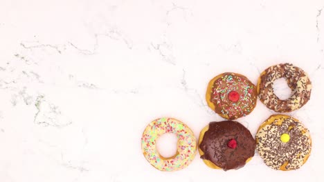 deliciosas rosquillas con chocolate aparecen y desaparecen en el fondo de mármol - detenga el movimiento