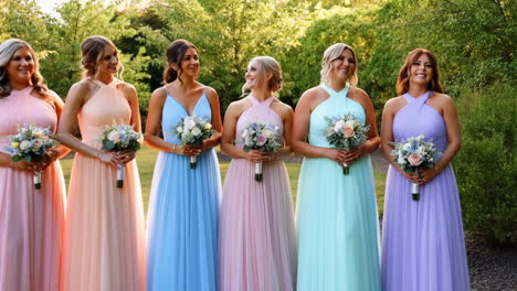 bridesmaids in pastel dresses holding bouquets