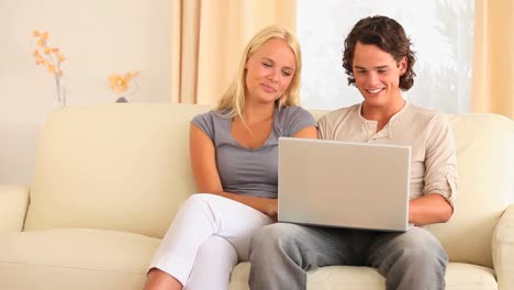 Couple-sitting-on-a-sofa-searching-the-web