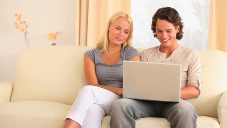 pareja sentada en un sofá buscando en la web