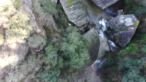 antena: toma cenital de un río a la sombra con unas pequeñas cascadas