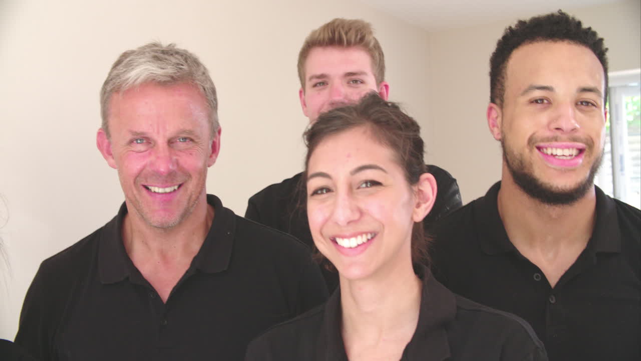 el equipo de decoración sonriente, de mano, disparo de panorámica en cámara lenta