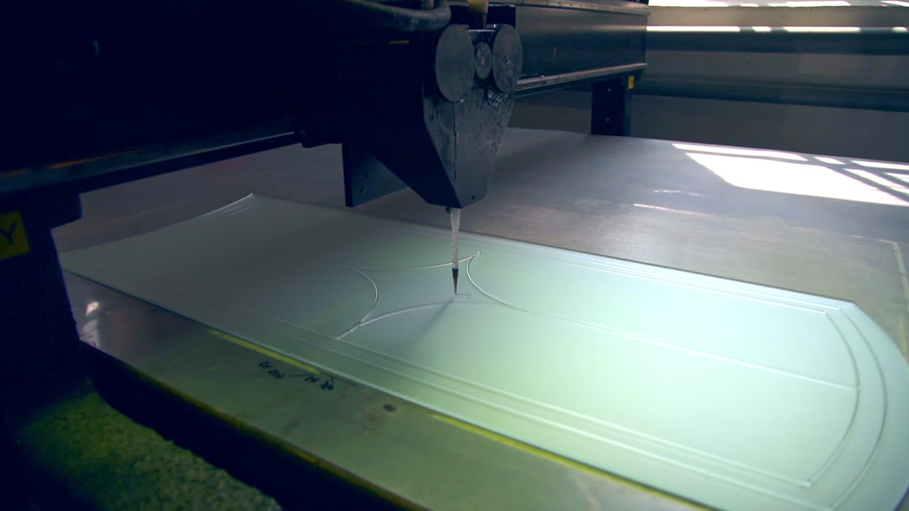 Thin applicator of automatic machine draws lines on the glass. Door décor at the modern door production.