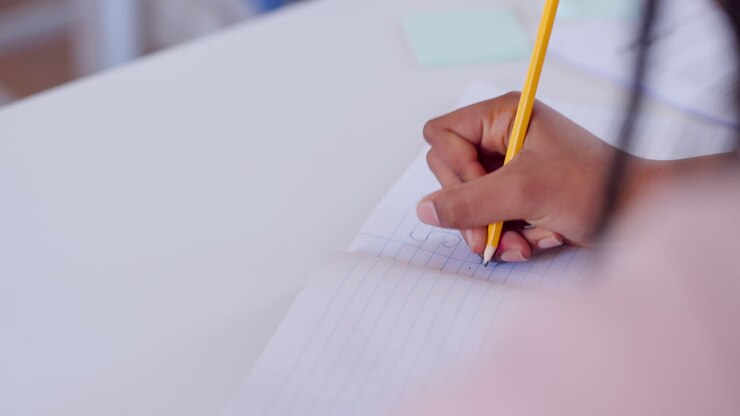 Student, hand and writing in notebook