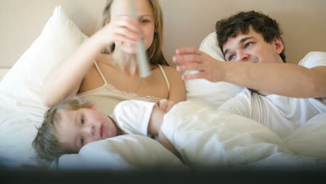 Familia-Feliz-De-Tres-Personas-Viendo-Televisión-Por-La-Mañana