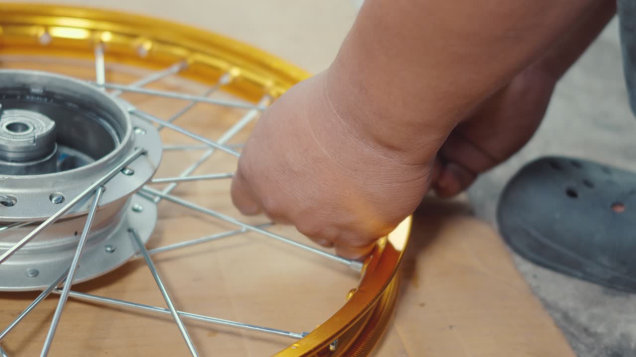 técnico hombre trabajando rueda de motocicleta tiene rayos tejer en mecánico nueva rueda de acero