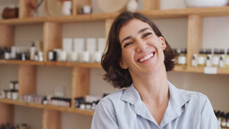 retrato de la dueña de la tienda de regalos de pie frente a los estantes con cosméticos y velas
