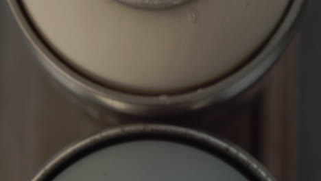 top sliding view of messy used spray paint cans. close up