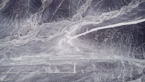 top down aerial, desert plateau landscape with the nazca lines and humanoid creatures, historical landmark in peru