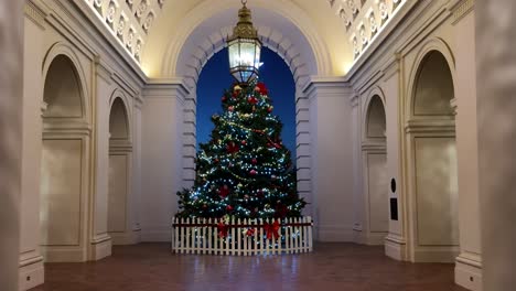 pasando entre columnas hacia el árbol de navidad decorado dentro del ayuntamiento de pasadena