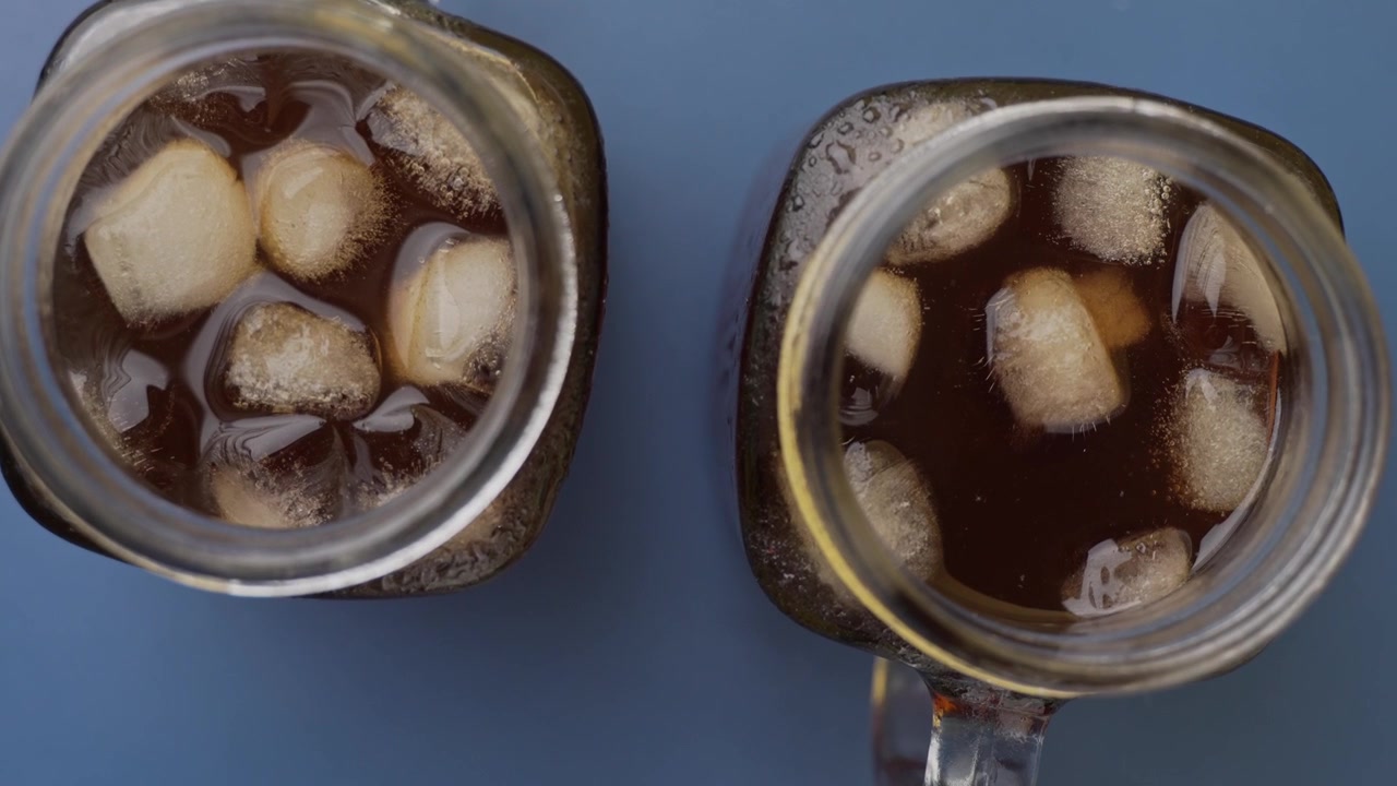 Bicchieri di caffè freddo con cubetti di ghiaccio visibili, video in primo piano.