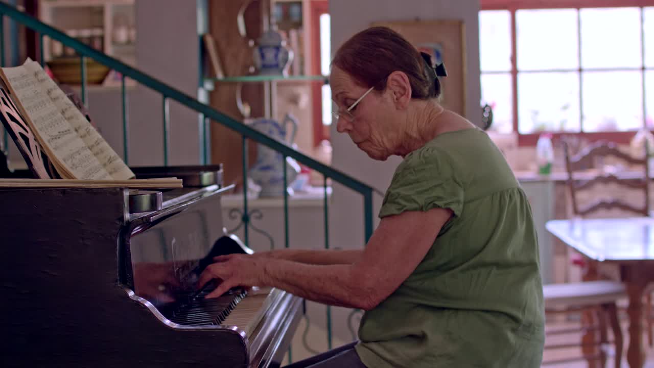 anciana tocando un piano de cola en su casa