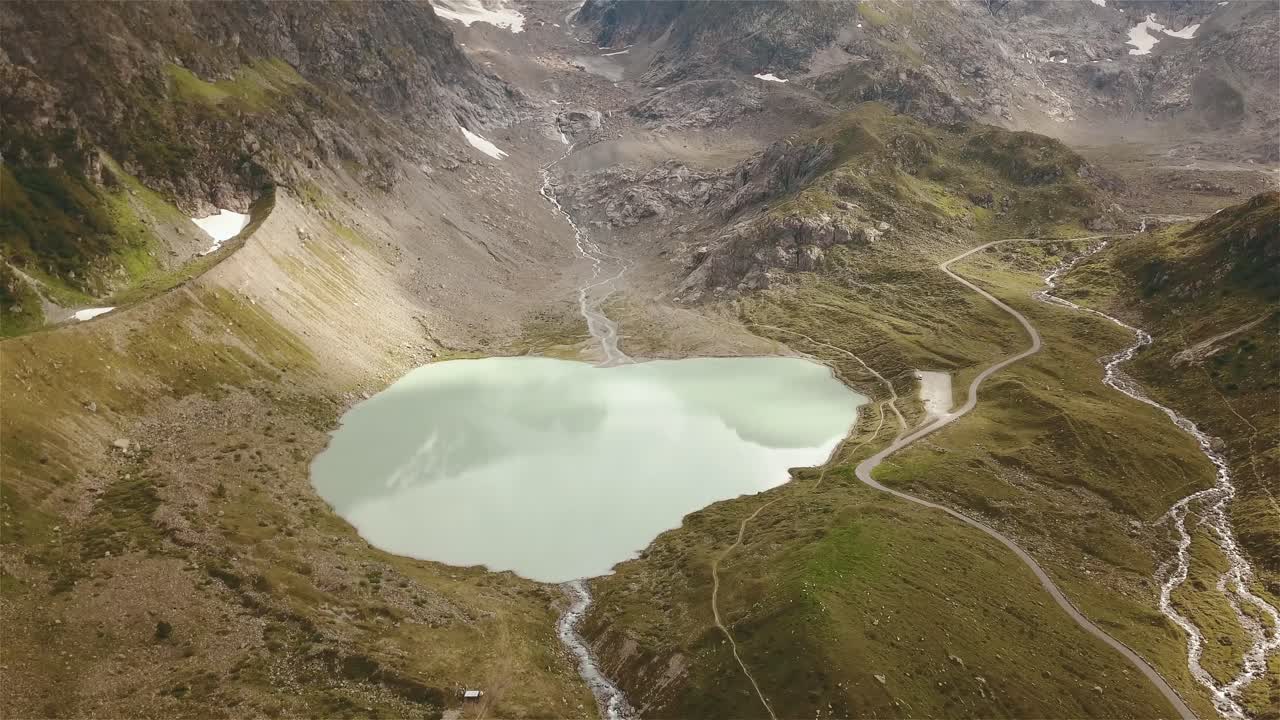 카메라가 4k로 스위스의 산악 호수 위로 기울어져 앞뒤로 날아가는 드론 샷
