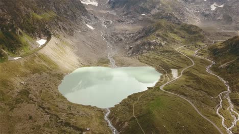 Drohnenaufnahme,-Die-Rückwärts-Und-Aufwärts-Fliegt,-Wobei-Die-Kamera-In-4k-über-Einen-Bergsee-In-Der-Schweiz-Geneigt-Ist