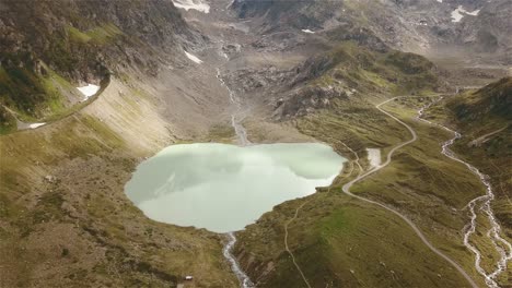 disparo de drones volando hacia atrás y hacia arriba con la cámara inclinándose sobre un lago de montaña en suiza en 4k