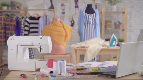 sewing machine and sewing supplies on the table in the studio of a fashion designer,nobody