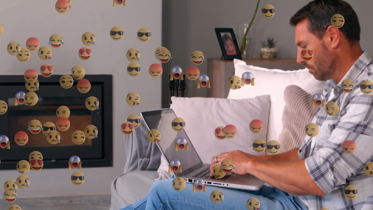 animación de iconos emoji sobre un hombre caucásico usando una computadora portátil en casa