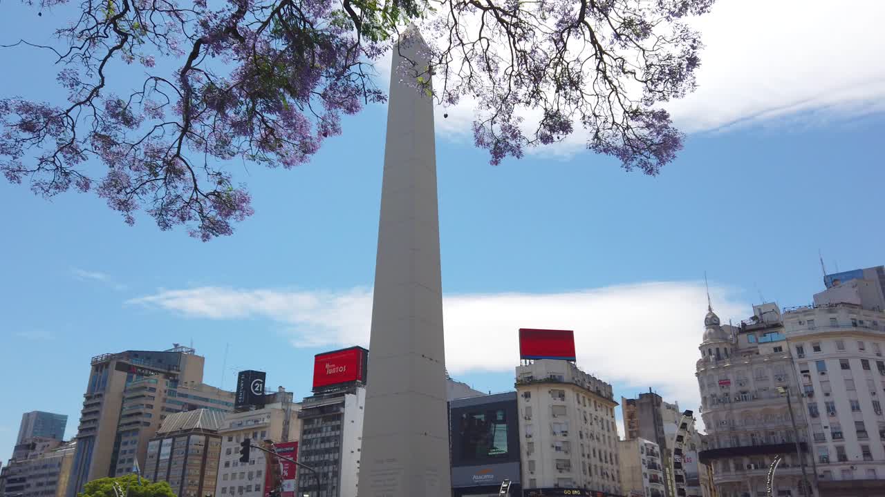 Downtown cityscape of Buenos Aires Argentina with Obelisk and billboards in 9 de Julio Avenue, Jacarandá trees in bloom