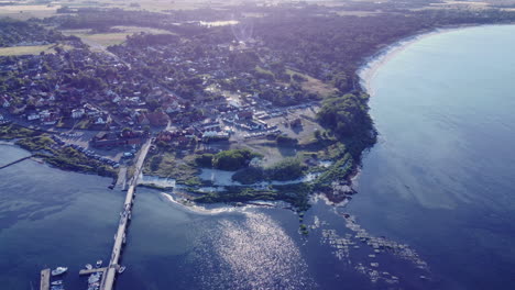 Drone-Approaching-A-Harbour-With-Blue-Ocean-Bornholm-Denmark